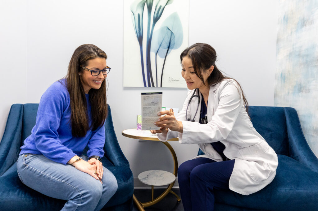 A healthcare professional smiles while discussing the ozone sauna in Hendersonville, TN, with a female patient