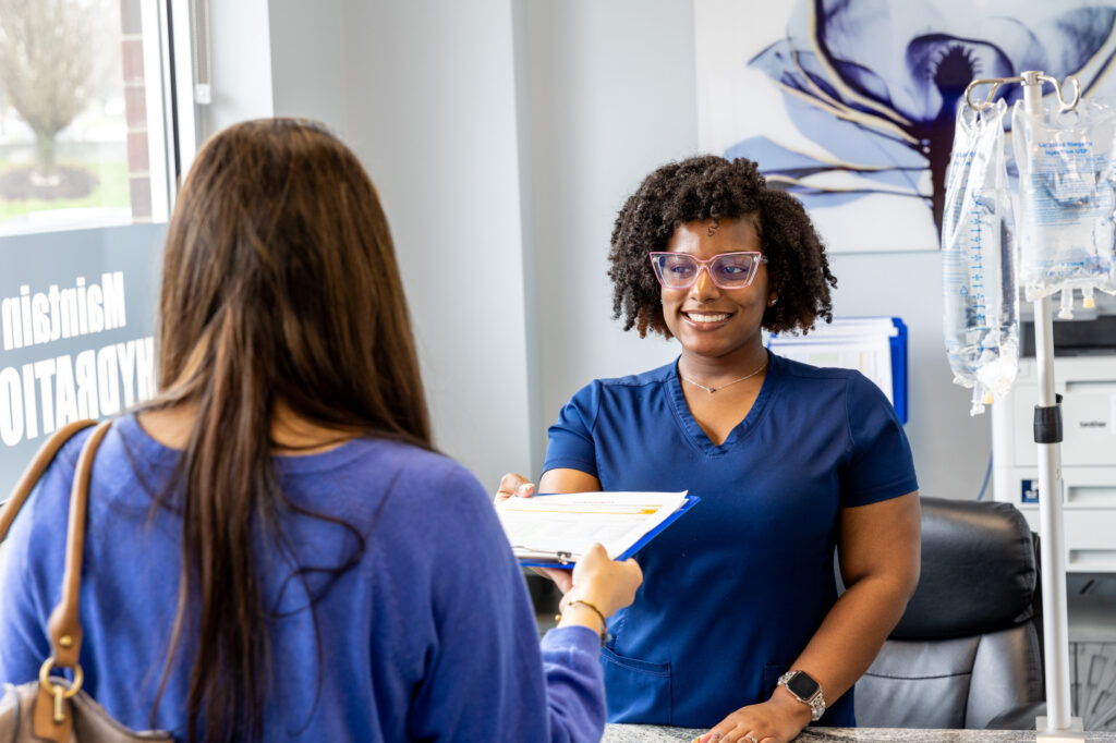 A female patient smiles at a nurse before filling out paperwork for weight loss in Nashville