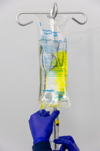 A nurse with blue gloves prepares an IV bag for keeping hydrated in Nashville