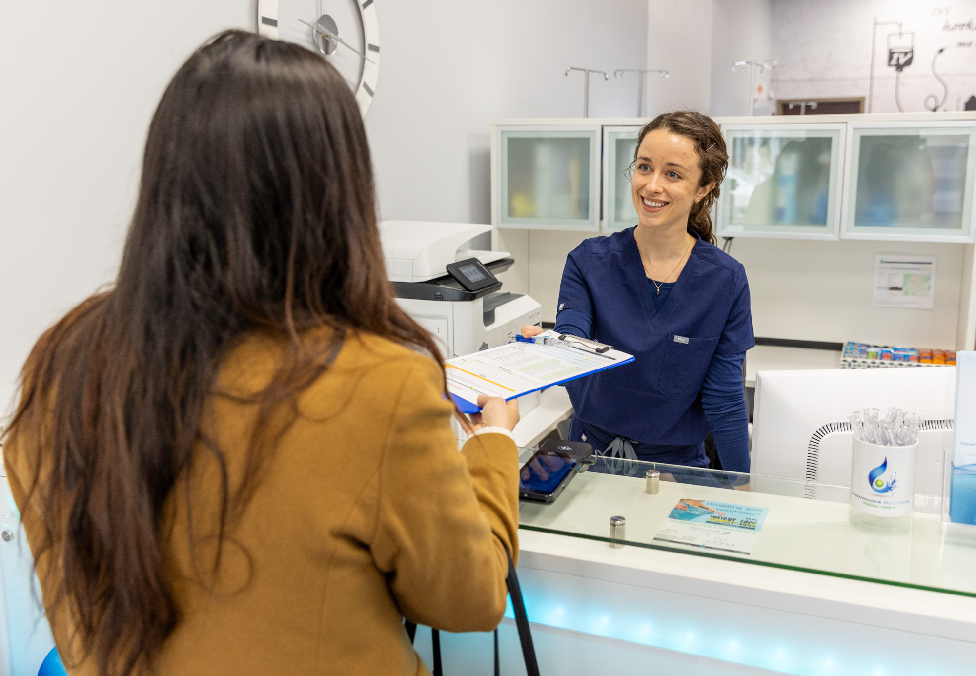 A woman smiles while greeting a patient for dermal fillers in Nashville