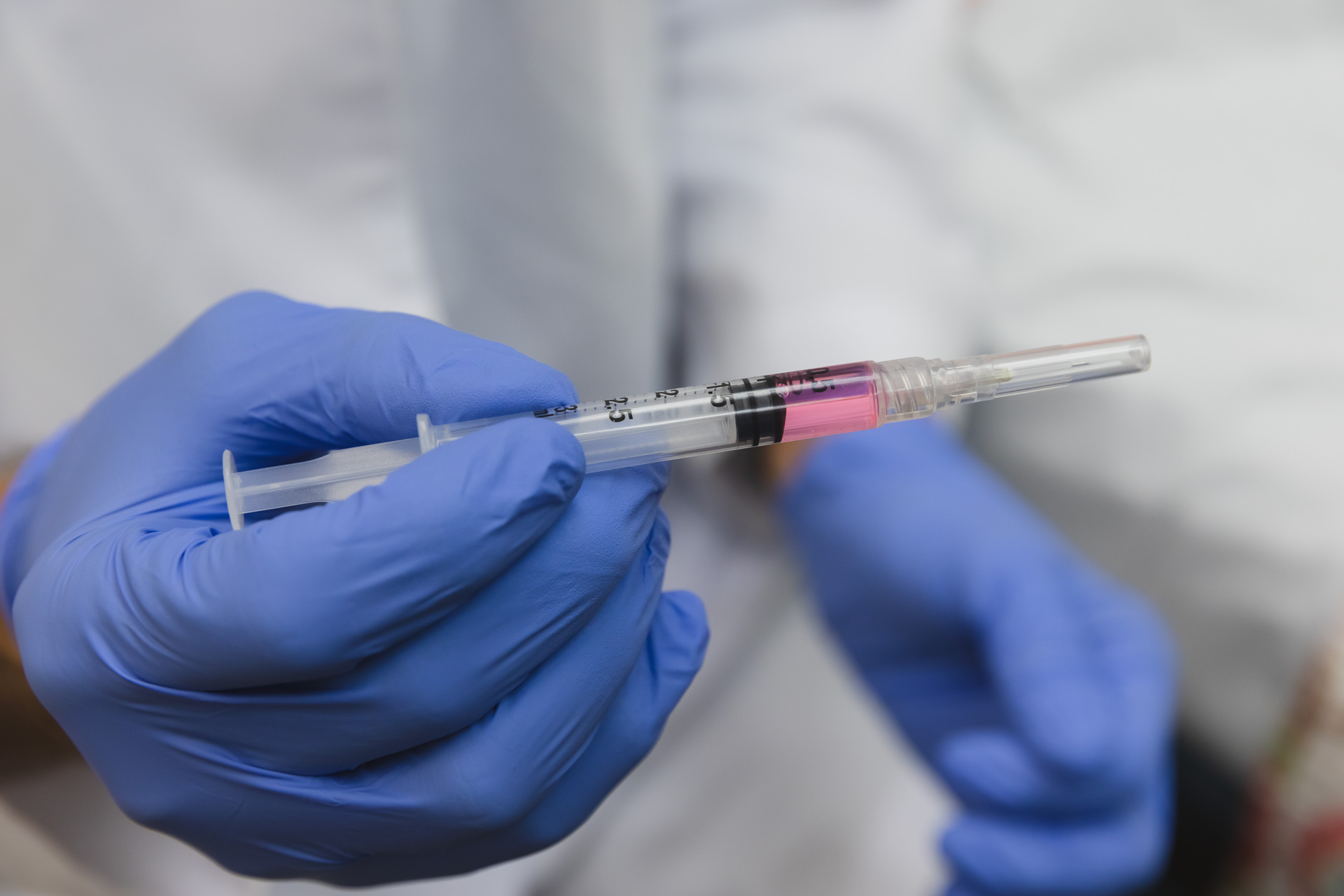 A provider wearing a white jacket and blue gloves prepares weight loss injections in Hendersonville, TN