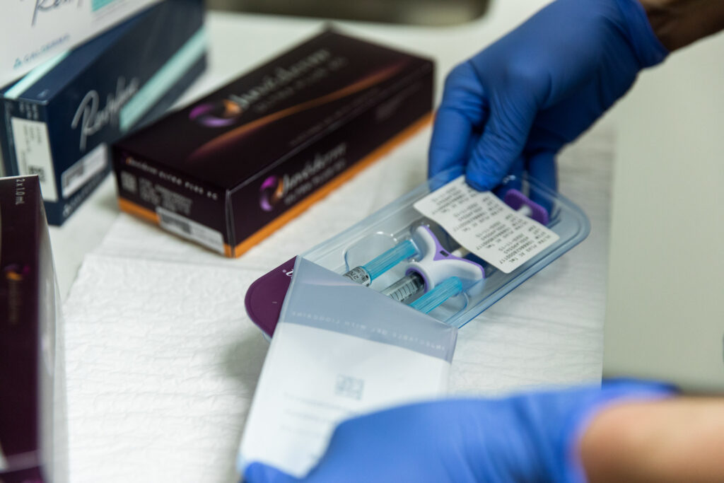 Gloved hands opens package of product to administer lip filler in Nashville