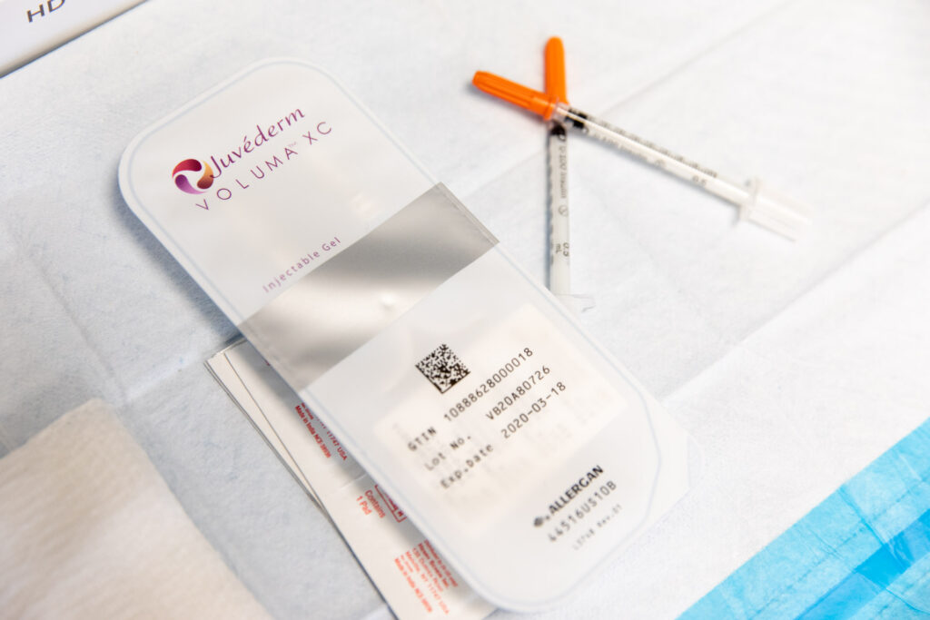 two syringes placed next to Juvederm Voluma package for dermal fillers in Nashville