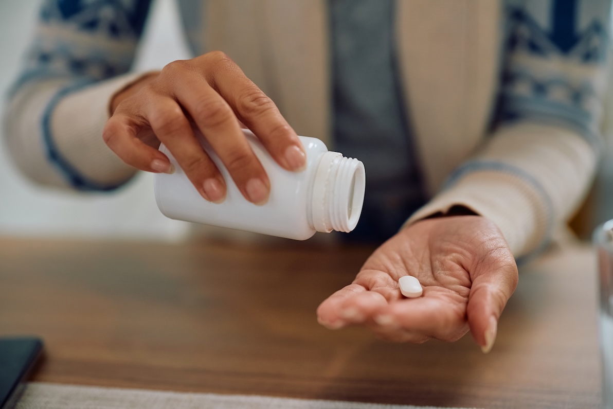 A woman shakes oral pain relievers out of a pill bottle to use as hangover relief after bachelorette party activities in Nashville.
